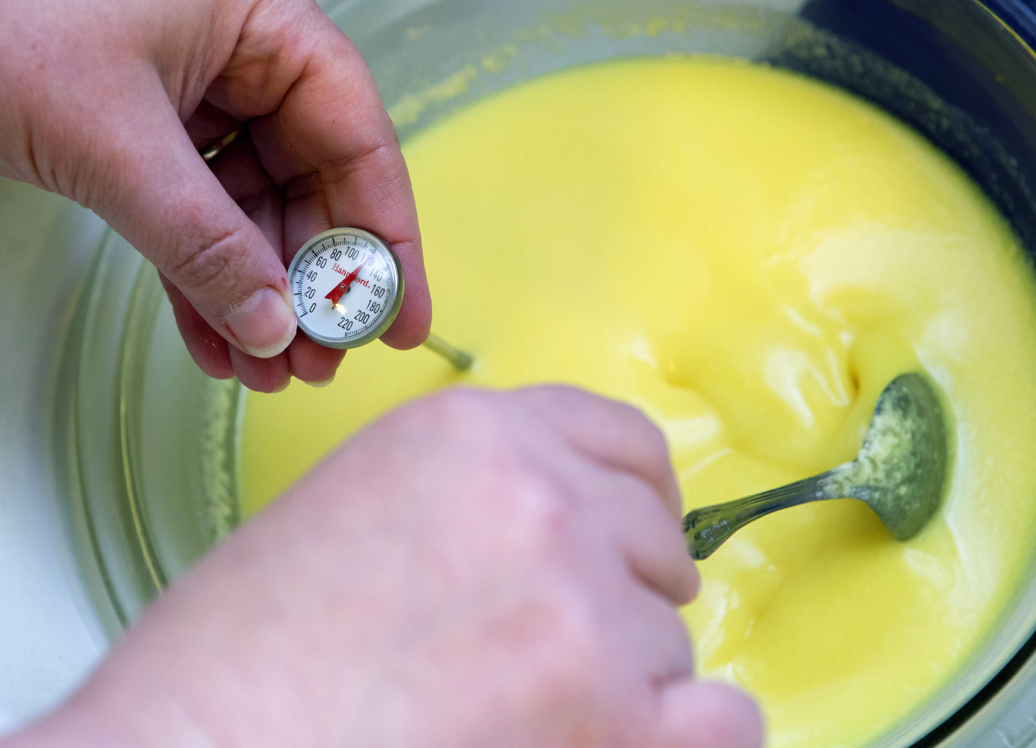 Check the temperature of the lye-goat milk mixture while making soap | Ashley L. Conti