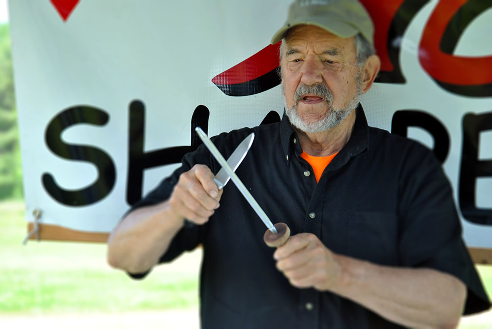 Neill Peterson, owner of ACE Sharpening and Window Cleaning in Belfast, Maine, demonstrates how to care for kitchen knives at the Maine Organic Farmers and Gardeners Association's annual Farm and Homestead Day in 2019.