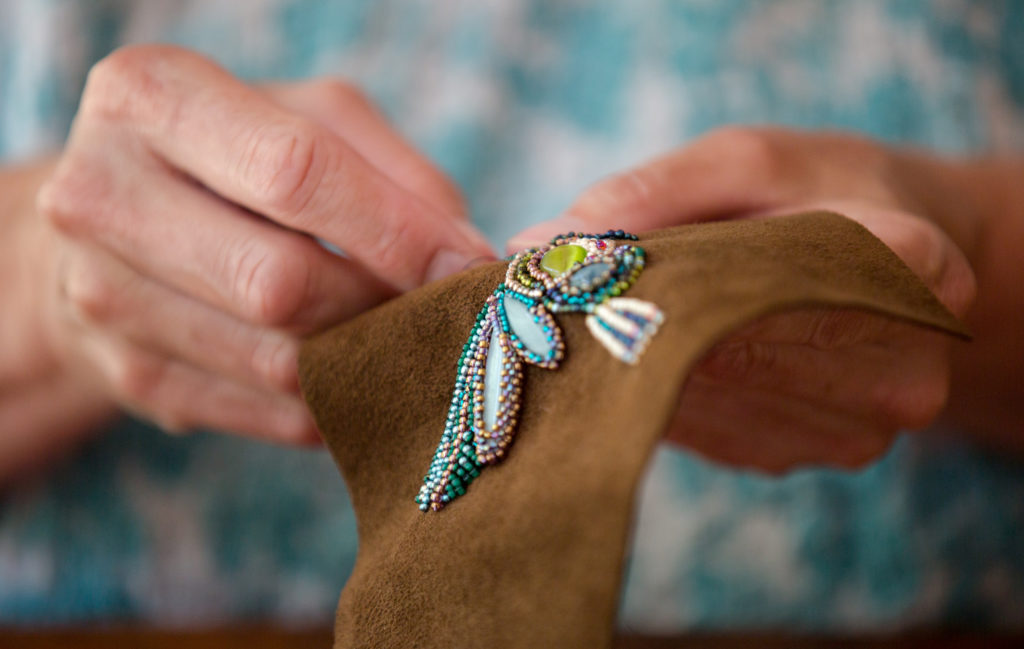 Leslie Jones embroiders beads into a hummingbird pattern at her home in Southwest Harbor, Maine. If trying to discover crafts that make money, it may be helpful to hone in on a specialty, like embroidering specific types of beads into nature scenes. You can then perfect that craft, plus your work becomes recognizable to customers.