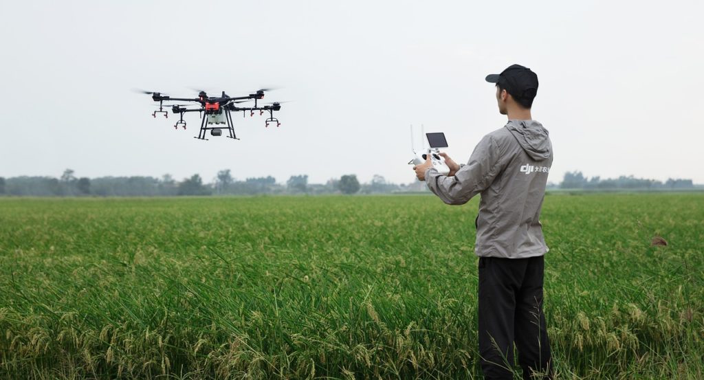 A man operates a drone in a field.