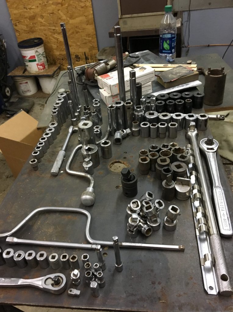 Sockets of various sizes organized on a metal table.