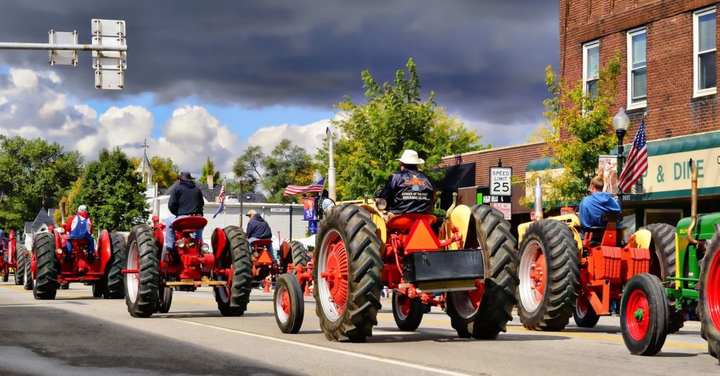 A parade of antique, red tractors.